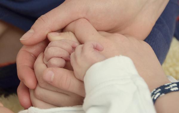 Baby Hände in den Händen der Eltern