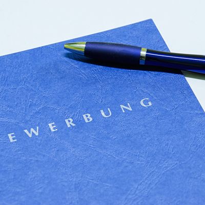 Blaue Bewerbungmapp mit blauem Kugelschreiber